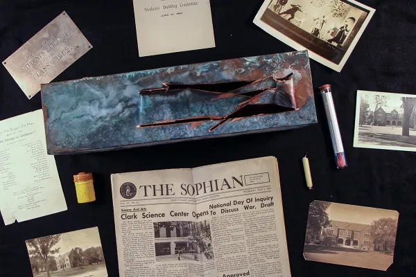 Collection of items being added to a time capsule including letters and photos