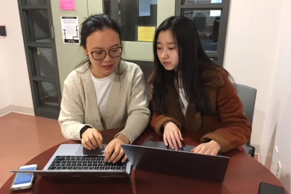 Yuqing Geng ‘21 (left) and Qiaqia Ji ’20 review stock histories in preparation for the Midwest Trading Competition in Chicago. Isabella Zhu ’20 is also on the team.
