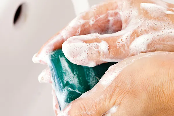 Close up of hands being washed in a sink