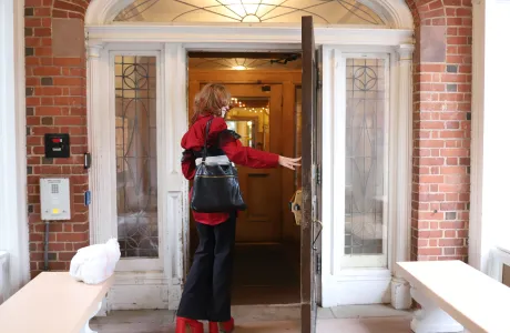 A student opening the door to a Smith house.