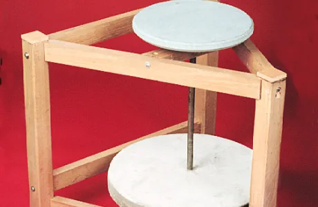 A wooden frame with circular sandstones stacked vertically