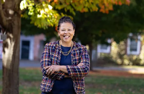 Sarah Willie-LeBreton stands under a tree in the fall at Smith College