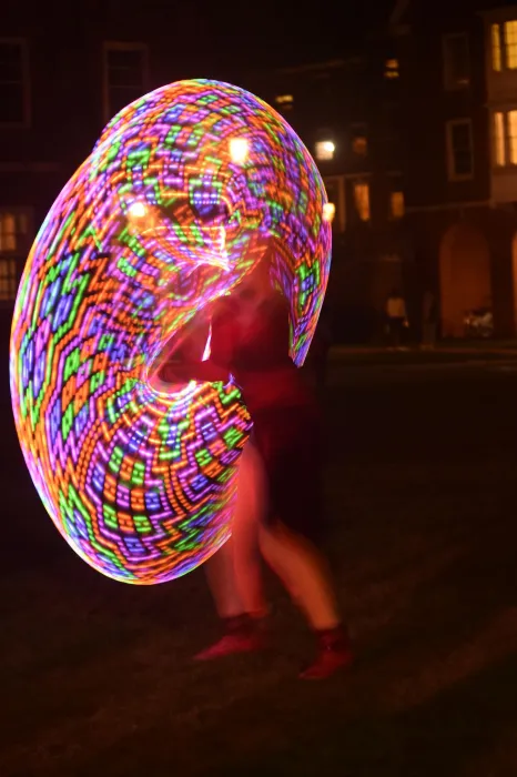 Una Fonte is a blur of rainbow colors while dancing with LED hula hoops at night