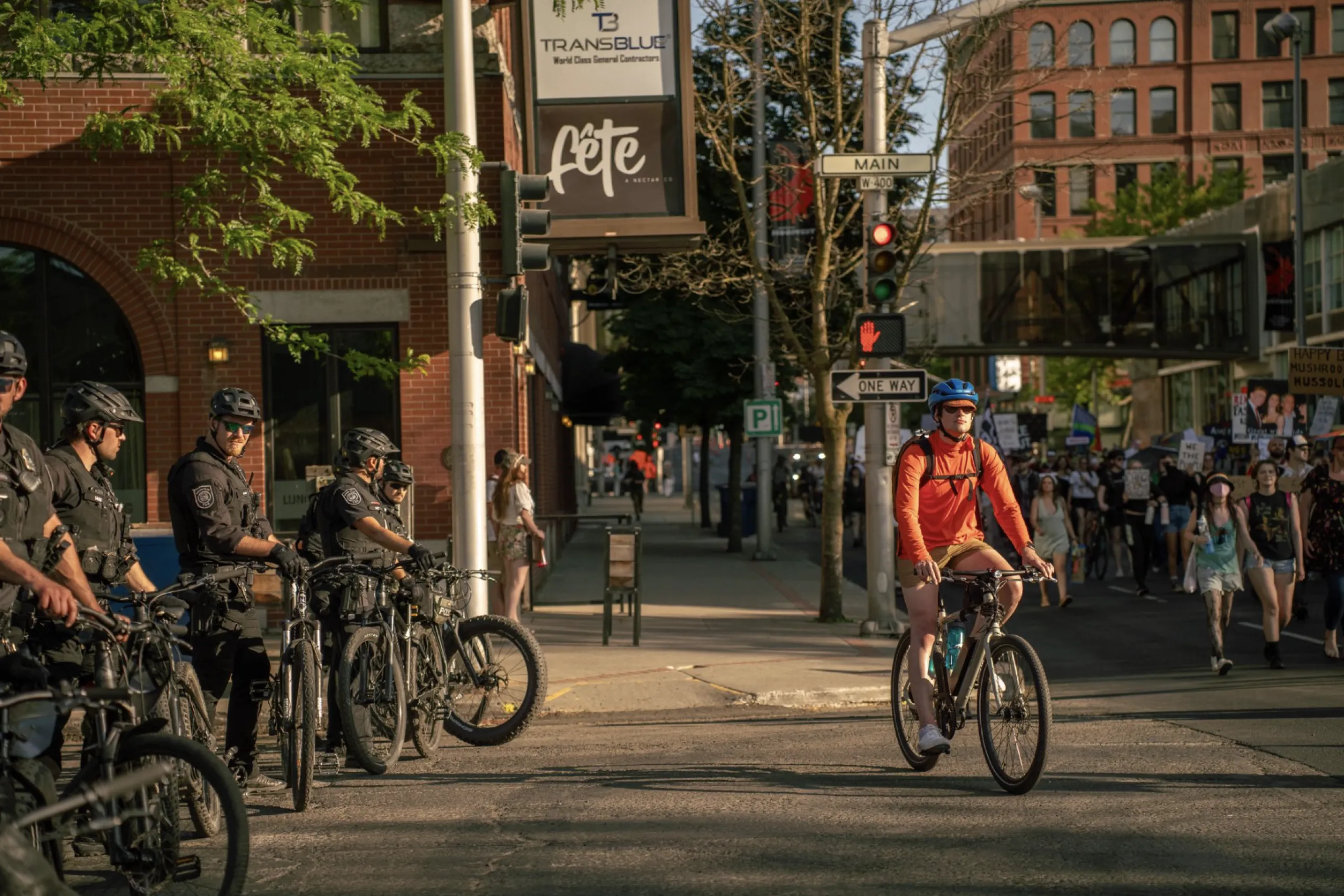 A line of police officers on bicycles watch a protest.