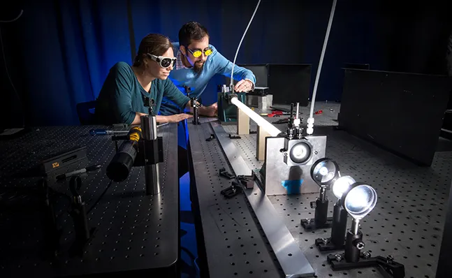 Assistant Professor Andrew Berke with student in laser lab