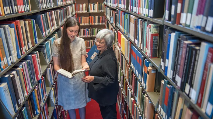 Student and librarian in the stacks in Josten Library