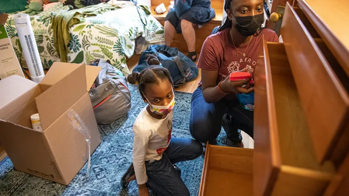 a student and child setting up a new room’s dresser
