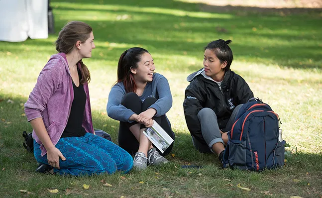 Three students on the lawn at the Neilson groundbreaking