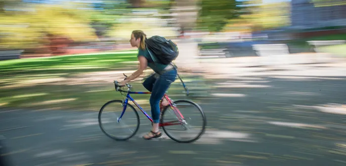 Student riding a bike on campus