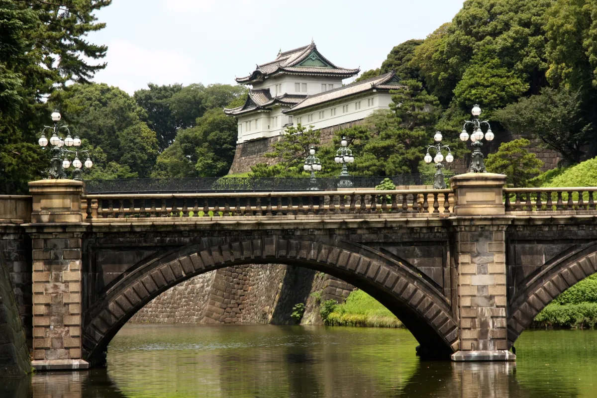 a stone bridge spans a river in Japan