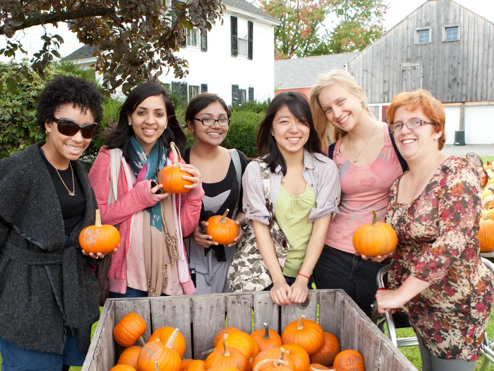 Smith students in 2011 holding mini pumpkins on Mountain Day