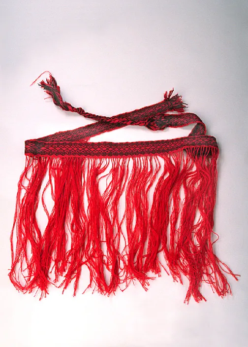 A red and black woven skirt with long, flowing fringes