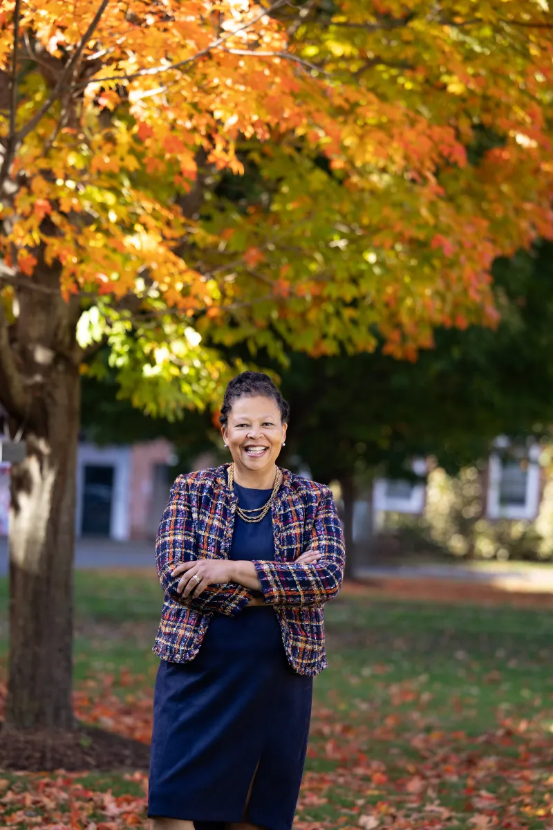 Sarah Willie-LeBreton stands under a tree in the fall at Smith College
