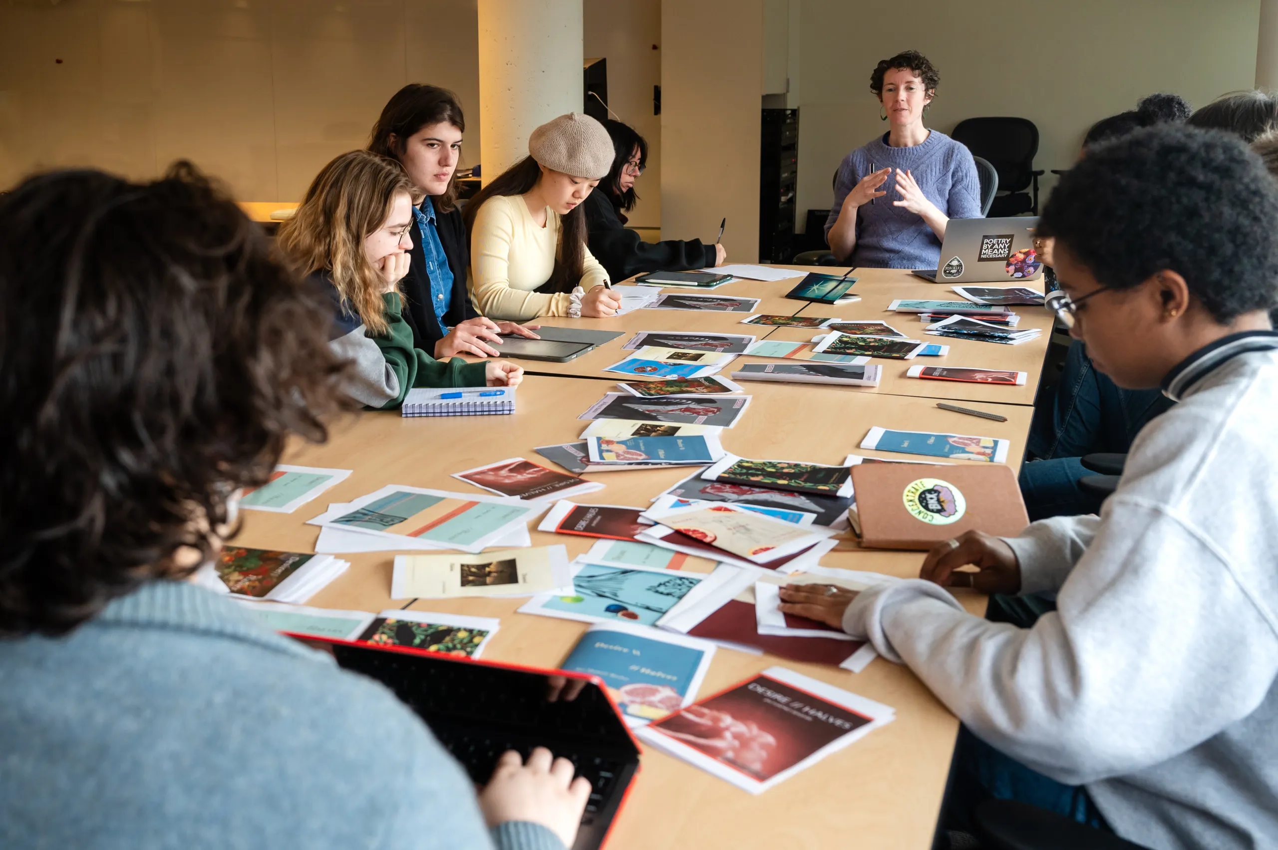 Adrie Rose talks to a class of students seated around a long table