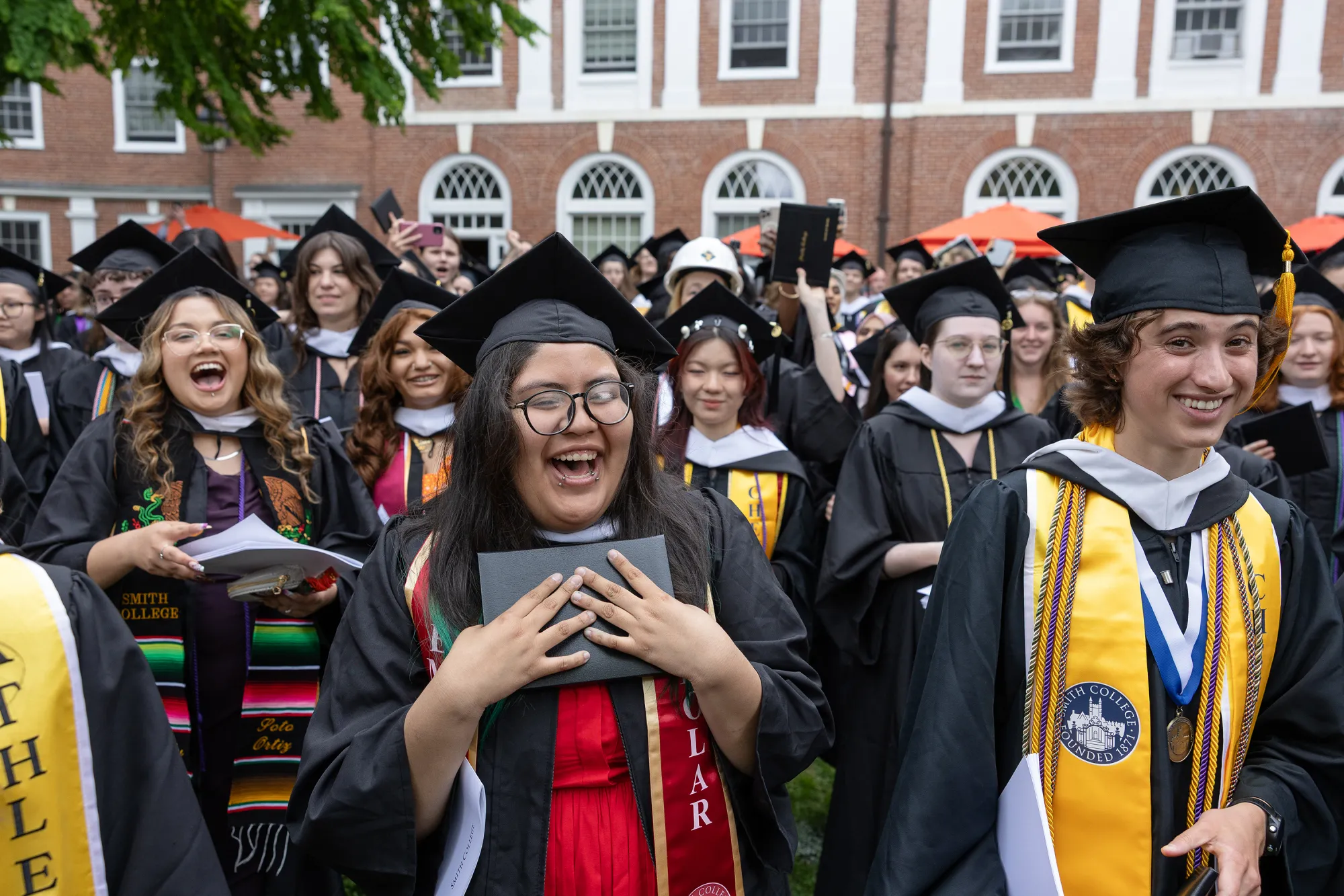 A graduate clutches their diploma after the diploma circle.