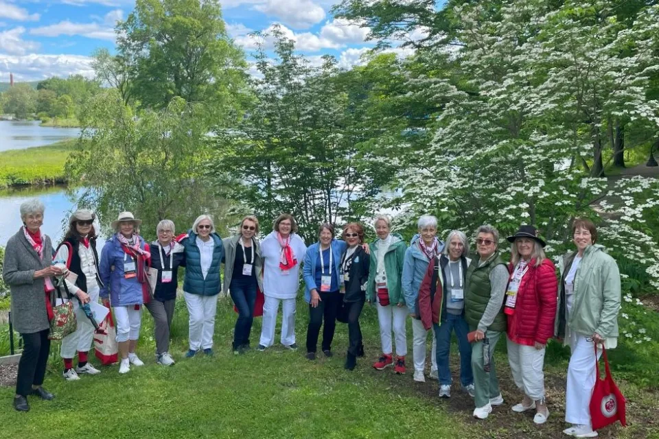 Class of 1970 members posing and smiling by Memorial Tree