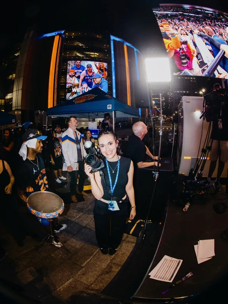 Elie Pichanick smiles for a photo while holding up her own camera during a New York Knicks watch party.
