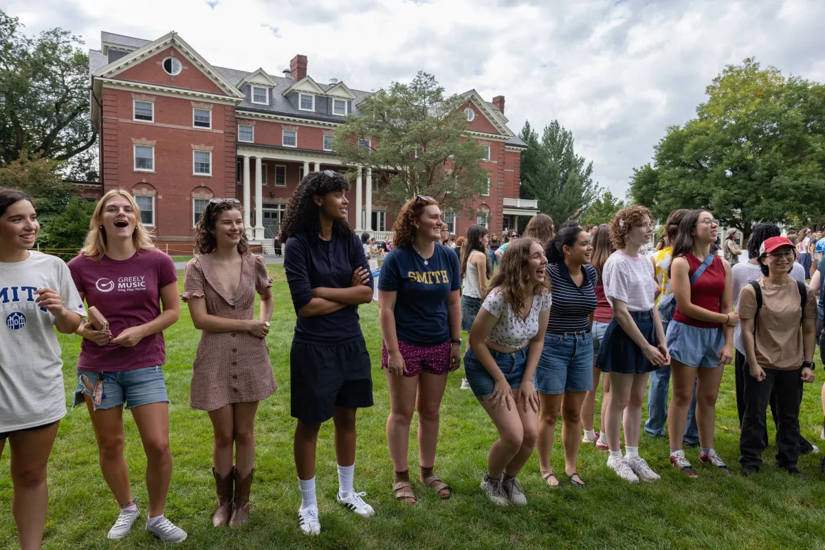 New students stand on Chapin lawn in a line, laughing during Orientation