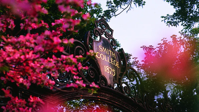 Photo of the top of the Grecourt Gates, displaying "Smith College 1875" in gold lettering