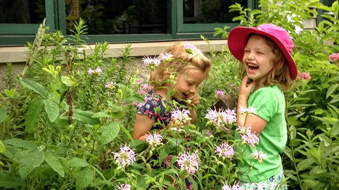 Two girls looking at flowers outside