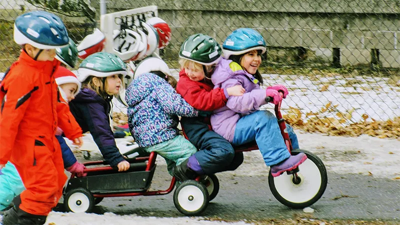 Group of children pulling a wagon behind a bike