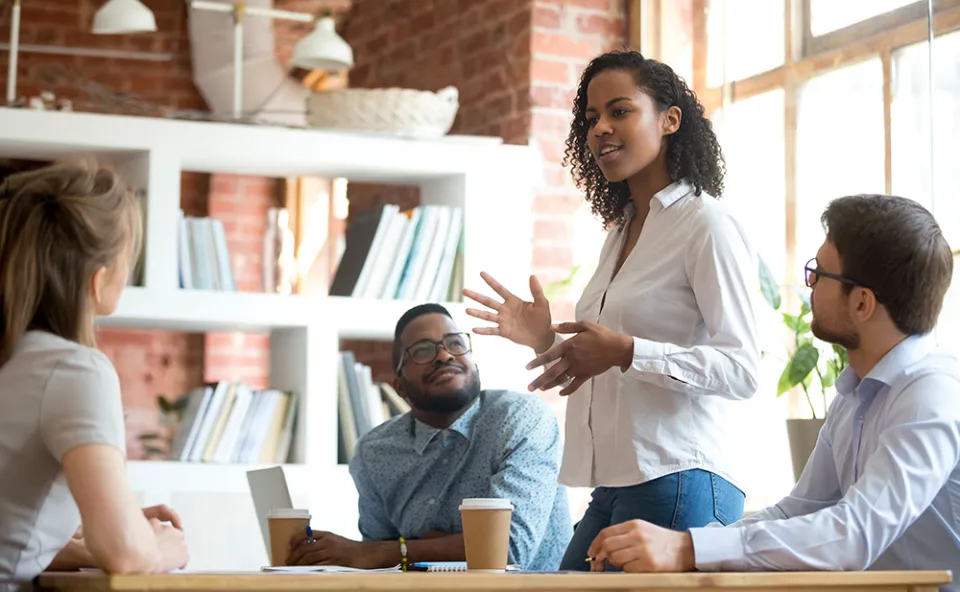 Young woman employee speaking at a business meeting