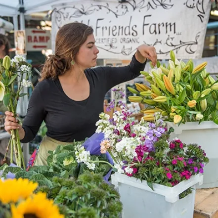 A vendor selling fresh-cut flowers at a farmer's market in downtown Northampton.