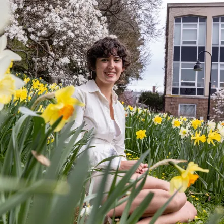 Gabriela Eastwood sitting among daffodils at Smith College.