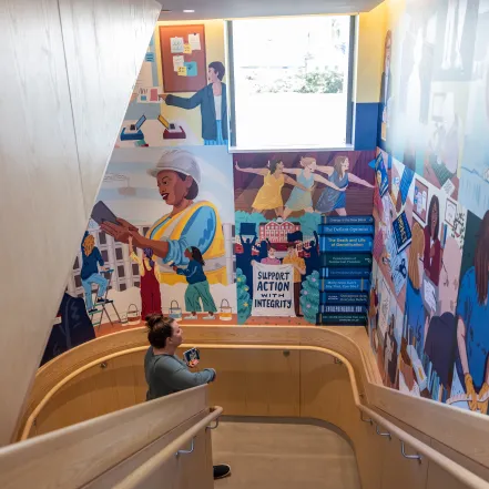 Someone stands and admires the new mural in Kathleen McCartney Hall.